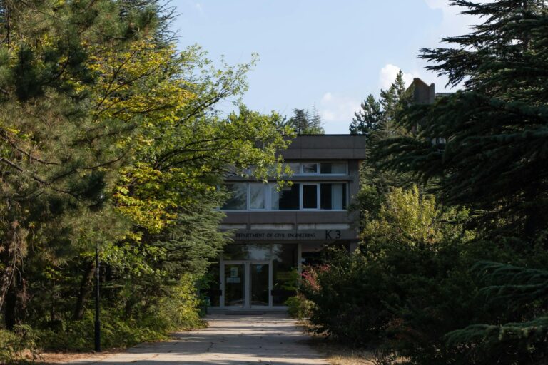 A contemporary university building nestled in lush greenery, capturing academic serenity.