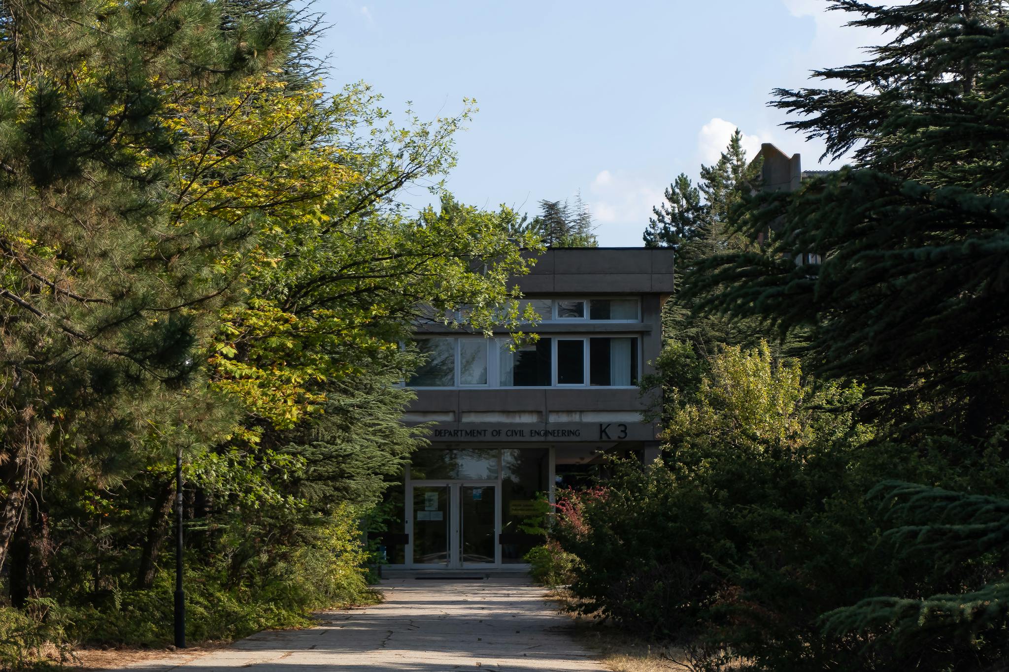 A contemporary university building nestled in lush greenery, capturing academic serenity.