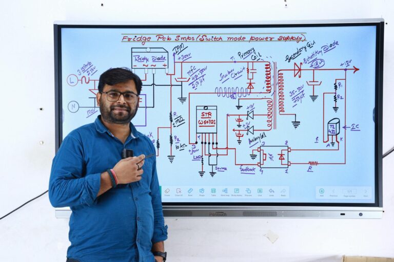 Instructor in New Delhi teaching electronics with a circuit diagram on screen.